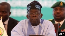 Chairperson of Economic Community of West African States (ECOWAS) and President of Nigeria, Bola Ahmed Tinubu, reacts while addressing the ECOWAS head of states and government in Abuja on July 30, 2023