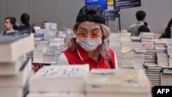 Seorang pengunjung pameran buku di Jakarta mengenakan masker untuk melindungi dari penularan virus corona, 8 Maret 2020. (Foto: AFP)