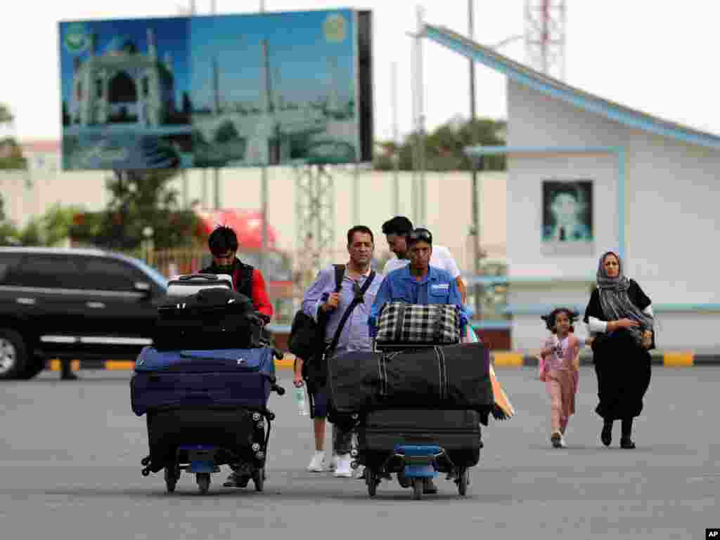 Passengers walk to the departures terminal of Hamid Karzai International Airport in Kabul, Aug. 14, 2021.