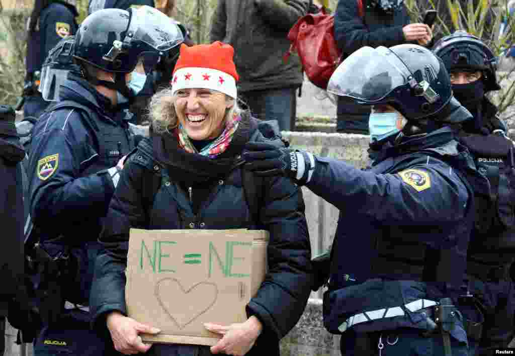 Seorang perempuan bereaksi saat melakukan protes terkait pembatasan COVID-19, di Ljubljana, Slovenia, 27 Desember 2021. (Foto: REUTERS/Borut Zivulovic)