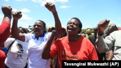 FILE: Zimbabwean war veterans who had gathered to demonstrate against a faction within the ruling Zanu PF party, reportedly led by the First Lady Grace Mugabe, vent their anger after they were dispersed by police using tear gas and water cannons in Harare, Thursday, Feb. 18, 2016. (AP Photo/Tsvangirayi Mukwazhi)