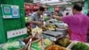 Seorang pedagang acar melayani pelanggan di pasar pagi di Beijing, China, 9 Agustus 2023. (Tingshu Wang/REUTERS)