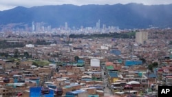 Los teleféricos utilizados como transporte público al barrio de Ciudad Bolívar se mueven sobre las casas en Bogotá, Colombia, el martes 6 de junio de 2023. 