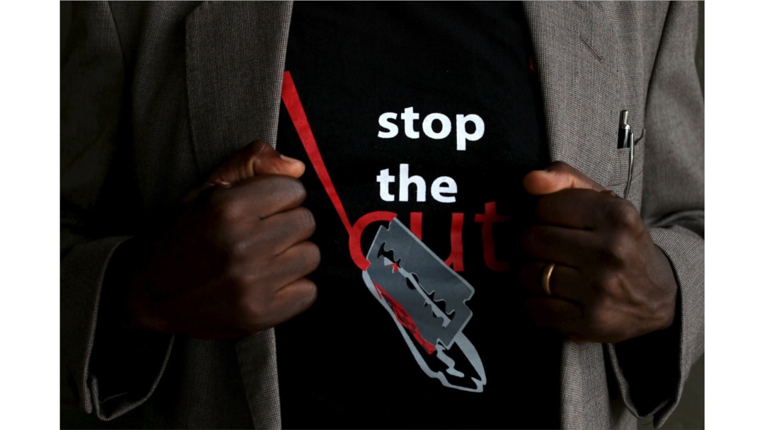 FILE - A man shows the logo of a T-shirt that reads "Stop the Cut" referring to Female Genital Mutilation (FGM), in Imbirikani, Kenya, April 21, 2016