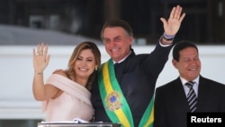 Presiden Brazil Jair Bolsonaro dan istrinya, Michelle Bolsonaro, melambaikan selama pidatonya di Istana Planalto, di Brasilia, Brazil 1 Januari 2019. (Foto: REUTERS/Sergio Moraes)