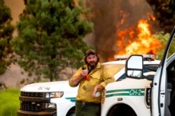 U.S. Forest Service firefighter Chris Voelker monitors the Sugar Fire, part of the Beckwourth Complex Fire, burning in Plumas National Forest, Calif., July 9, 2021.