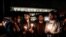 Demonstrators hold candles during a gathering in front of the Acropolis museum at the foot of the Acropolis hill in Athens, Sunday Jan. 18, 2015.