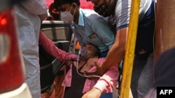 A patient breathes with the help of oxygen provided by a Gurdwara, a place of worship for Sikhs, outside a parked car along the roadside amid the coronavirus pandemic in Ghaziabad, April 26, 2021. 