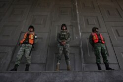 Soldiers stand guard to watch for passing migrants riding in public transportation in Tapachula, Chiapas state, Mexico, Sunday, June 9, 2019.