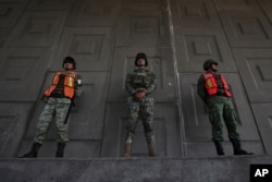 Soldiers stand guard to watch for passing migrants riding in public transportation in Tapachula, Chiapas state, Mexico, Sunday, June 9, 2019.