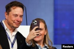 FILE - A delegate takes a selfie with Elon Musk, CEO of Tesla and X at the AI Safety Summit in Bletchley Park, near Milton Keynes in Britain, November 1, 2023 .