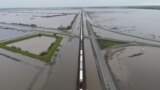 A train passes as floodwaters from the Tule River inundate the area after days of heavy rain in Corcoran, California, U.S. on March 22, 2023. (REUTERS/David Swanson)
