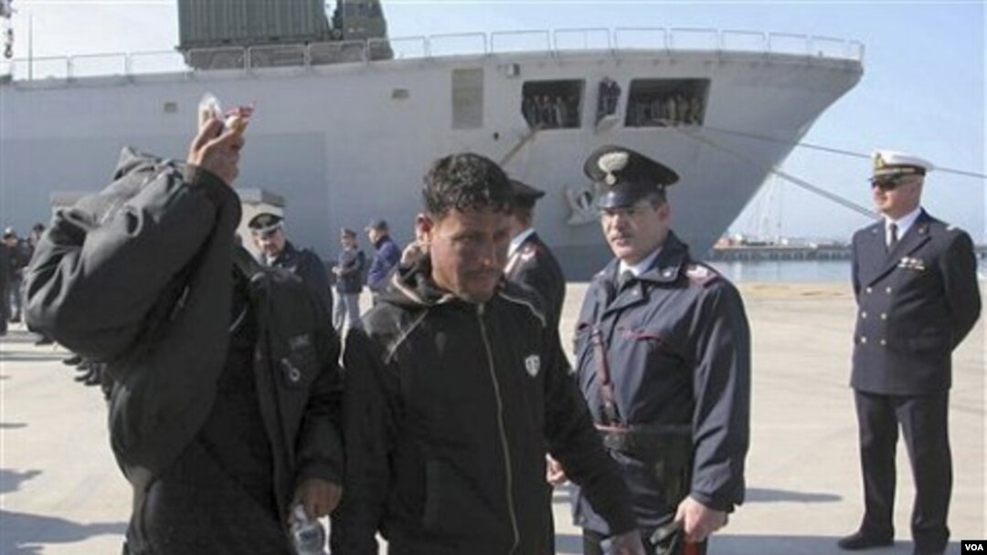 Para pengungsi dari Libya tiba di pelabuhan Taranto, Italia bagian selatan, Senin (28/3).