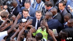 French President Emmanuel Macron (C) meets residents as he leaves the Ouagadougou University after giving a speech, Nov. 28, 2017, in Ouagadougou, as part of his first African tour since taking office.