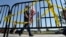 FILE - Pedestrians walk past a barricade preventing them from entering the World War II Memorial in Washington, Oct. 2, 2013, during a government shutdown. Another government shutdown looms if Congress does not agree on funding continued operations by Dec. 8.