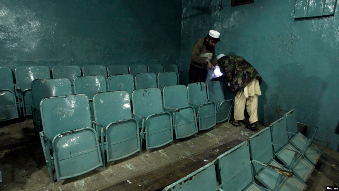 Petugas keamanan mengumpulkan bukti dari dalam bioskop tempat ledakan bom di Peshawar (2/2). (Reuters/Fayaz Aziz)