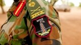 FILE - A Sudan People's Liberation Army (SPLA) commander dons his division's insignia in Bentiu, Unity State, South Sudan.