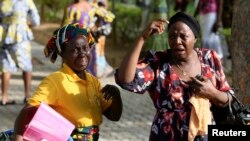 Bystanders react as victims of a bomb blast arrive at the Asokoro General Hospital in Abuja, April 14, 2014.