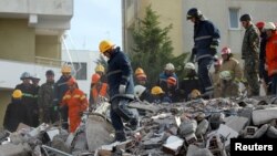 Emergency personnel work at the site of a collapsed building in the town of Durres, following Tuesday's powerful earthquake that shook Albania, Nov. 27, 2019.