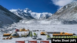 FILE - In this April 30, 2020, aerial file photo released by China's Xinhua News Agency, vehicles and tents are seen at the base camp at the foot of the Chinese side of the peak of Mount Qomolangma, also known as Mount Everest. (Purbu Zhaxi/Xinhua via AP, File)