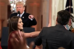 FILE - As President Donald Trump points to CNN's Jim Acosta, a White House aide takes the microphone from the reporter during a news conference in the East Room of the White House, Nov. 7, 2018, in Washington.