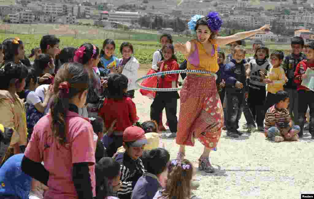 Những thành viên của nhóm Hề Không Biên giới giúp vui cho trẻ em tị nạn Syria ở Jab Janine, Tây Bekaa, Lebanon, ngày 2 tháng 6, 2014. Hề Không Biên giới là một tổ chức phi lợi nhuận quốc tế sử dụng tiếng cười để làm giảm bớt những đau khổ của trẻ em trong các trại tị nạn, các vùng xung đột và những khu vực bị thiên tai.