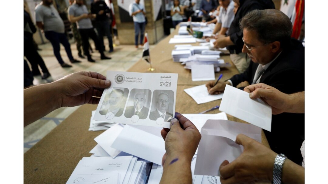 Poll workers count ballots after polls closed during the country's presidential elections in Damascus, Syria, May 27, 2021.