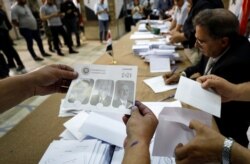 Poll workers count ballots after polls closed during the country's presidential elections in Damascus, Syria, May 27, 2021.