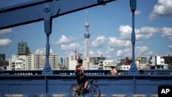 Seorang pengendara sepeda berhenti sejenak di jembatan di Tokyo, 28 September 2020. (Foto: AP/Eugene Hoshiko)