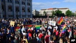 Orang-orang berkumpul dalam aksi mendukung hak asasi kelompok LGBT di depan gedung parlemen Hungaria di Budapest, pada 14 Juni 2021. (Foto: MTI via AP/Szilard Koszticsak)