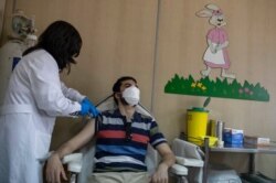 A man receives his first dose of the of the AstraZeneca COVID-19 vaccine, at a vaccination center in Piraeus, near Athens, April 29, 2021.