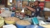 A Sudanese trader weighs produce at his stall in Rubkona Market in Unity state, South Sudan on March 14, 2013. (VOA/Bonifacio Taban)