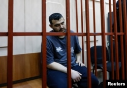 Uzbek national Akhmad Kurbanov, a suspect in the killing of Russian General Igor Kirillov, who was chief of Russia's Nuclear, Biological and Chemical Protection Troops, sits in an enclosure for defendants as he attends a court hearing in Moscow on Dec. 19, 2024.