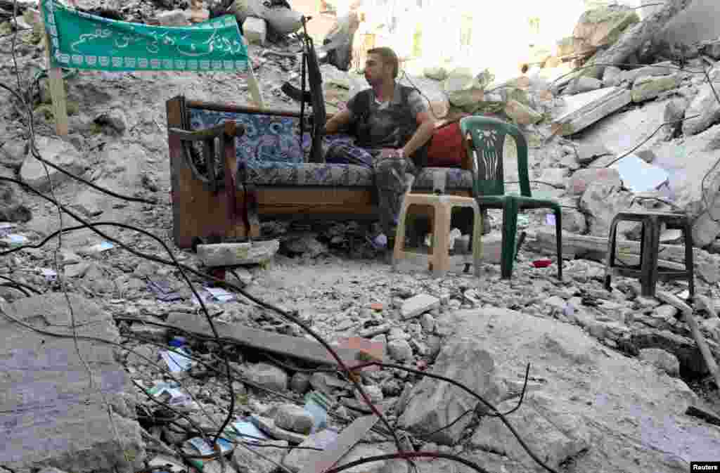 A Free Syrian Army fighter sits on a sofa along a street in Aleppo&#39;s Salaheddine neighborhood, July 31, 2013 