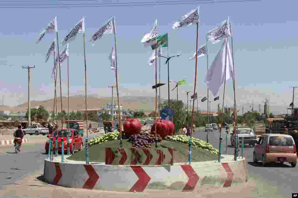 Taliban flags fly at a square in the city of Ghazni, southwest of Kabul, Afghanistan, Aug. 14, 2021.