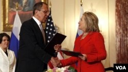 Menlu AS Hillary Clinton berjabat tangan dengan Menlu Rusia Sergey Lavrov setelah penandatanganan kerjasama bilateral di Washington (13/7).