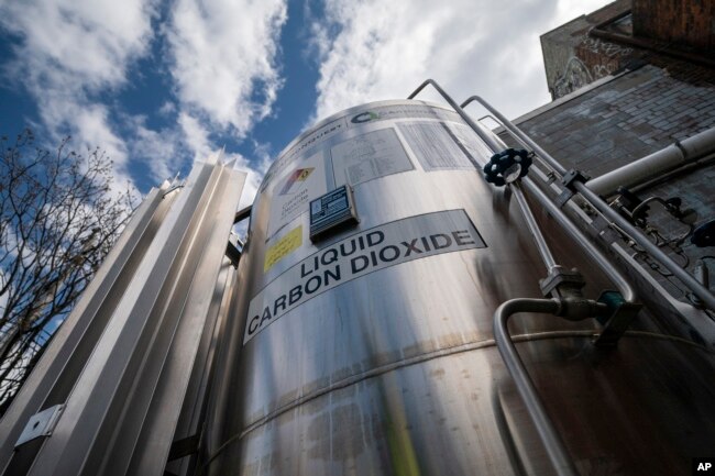 FILE - A liquid carbon dioxide containment unit stands outside the fabrication building of Glenwood Mason Supply Company, April 18, 2023, in the Brooklyn borough of New York. (AP Photo/John Minchillo, File)