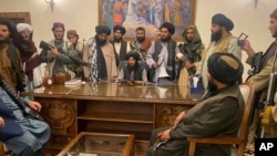 FILE - Taliban fighters take control of the Afghan presidential palace after President Ashraf Ghani fled the country, in Kabul, Afghanistan, Aug. 15, 2021.