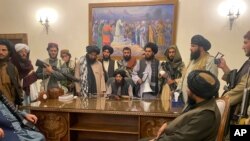 FILE - Taliban fighters take control of the Afghan presidential palace after President Ashraf Ghani fled the country, in Kabul, Afghanistan, Aug. 15, 2021.