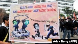 Para pengunjuk rasa menampilkan poster yang memperlihatkan Sjamsul Nursalim (kiri) dan Anthony Salim (kanan) yang dituduh menggelapkan jutaan dolar melalui BLBI selama krisis Asia pada 1998, Jakarta, 22 Juli 2008. (Foto: Adek Berry/AFP)