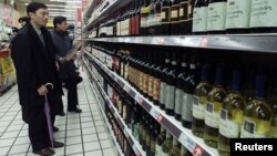 Chinese shoppers look at rows of wine at a supermarket in Shanghai. (Mar 2002 file photo)