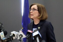 FILE - Oregon Gov. Kate Brown speaks at a news conference in Portland, Ore., March 16, 2020.