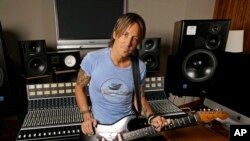 FILE - In this April 14, 2016, file photo, Keith Urban poses in Nashville, Tenn., to promote his latest album, "Ripcord." Urban leads nominations for the Academy of Country Music Awards with seven nominations as both artist and producer for his record “Ripcord.” The nominations were announced Thursday, Feb. 16, 2017, on “CBS This Morning.”