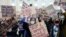 FILE - Women hold placards during a demonstration to call for gender equality and demand an end to violence against women, on International Women's Day in Brussels, Belgium, March 8, 2021. 