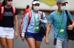 Tennis player Latisha Chan of Taiwan (C) leaves the hotel for a training session in Melbourne on Jan. 19, 2021, while quarantining for two weeks ahead of the Australian Open tennis tournament.