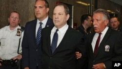 Harvey Weinstein (kedua dari kanan) diborgol tangannya saat dibawa memasuki ruang sidang di pengadilan New York, Senin (9/7). 