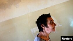 FILE - A patient is seen walking toward a group therapy room at a mental health institution in the Balkans.