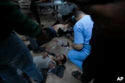 FILE - Palestinians wounded in the Israeli bombardment of the Gaza Strip are brought to Al Aqsa hospital in Deir al Balah, Gaza Strip, January 7, 2024.