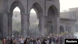 Protesters are seen amid remnants of teargas smoke during clashes with riot police at al-Azhar University in Cairo October 20, 2013. 