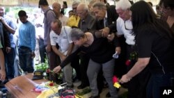 Amparo Salazar, madre del activista opositor Fernando Alban, coloca una rosa en su féretro antes de enterrarlo en Caracas, Venezuela. Octubre 10, 2018.